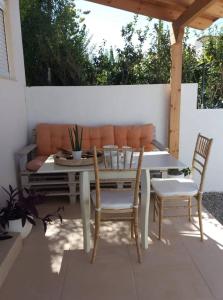 a patio with a table and chairs and a couch at Kedraki in Kalamaki