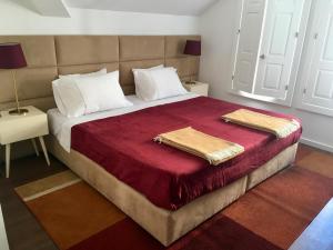a bedroom with a large bed with two towels on it at Casas Rosa Sousa in Felgueiras
