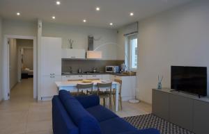 a living room with a blue couch and a kitchen at Vilu Suite Mare in Polignano a Mare