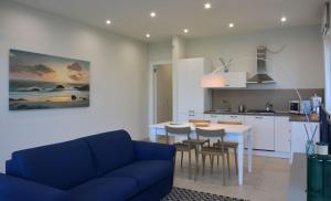 a living room with a blue couch and a kitchen at Vilu Suite Mare in Polignano a Mare