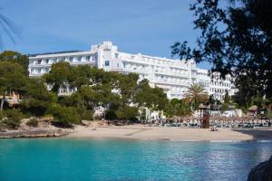 a large white building sitting on top of a beach at Grupotel Rocador - Adults Only in Cala d´Or