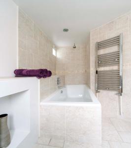 a white bathroom with a tub and a shower at The Art Apartment in Bath