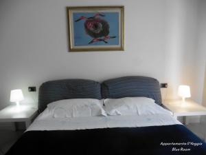 a bedroom with a bed with two lamps and a picture on the wall at Appartamento il Veggio in Poggio a Caiano