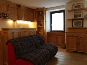 een woonkamer met een bank en een raam bij Casa Grangeon in La Thuile