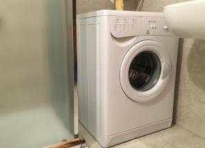 een wasmachine in een badkamer naast een muur bij Casa Grangeon in La Thuile