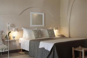 a bedroom with a large bed and a chair at Borgo San Gaetano in Bernalda