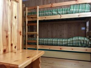2 stapelbedden in een kamer met een houten tafel bij Casa Grangeon in La Thuile