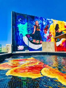 a pool with a painting on the side of a building at Cabane Container Hotel - ADULTS ONLY in Puerto Escondido