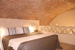 a bedroom with a bed with a brick wall at Borgo San Gaetano in Bernalda
