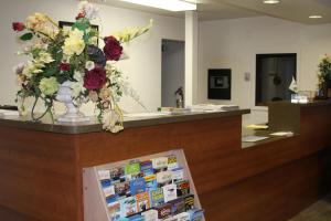 a reception counter with a vase of flowers on it at Days Inn & Suites by Wyndham Needles in Needles