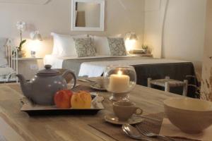 a table with a tea set with a candle and a bed at Borgo San Gaetano in Bernalda