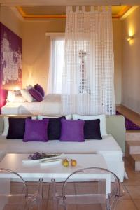 a hotel room with a large bed with purple pillows at Angelina Boutique Escape in Perdika