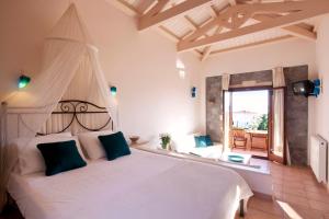 a bedroom with a white bed with a canopy at Angelina Boutique Escape in Perdika
