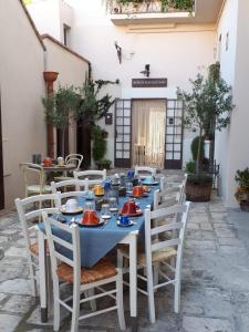 a long blue table with white chairs in a courtyard at Borgo San Gaetano in Bernalda