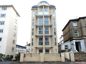 an apartment building in front of two buildings at The Sanctuary in Eastbourne