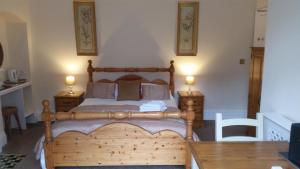 a bedroom with a wooden bed with two night stands at Rylstone Mere in Whitby