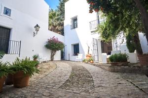 una calle adoquinada frente a un edificio blanco en Aljarafe Paradise by Valcambre, en Castilleja de la Cuesta