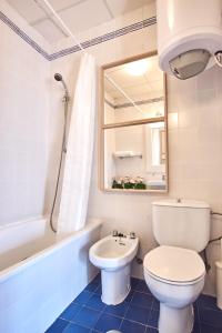 ein Badezimmer mit Toilette, Waschbecken und Spiegel in der Unterkunft Aljarafe Paradise by Valcambre in Castilleja de la Cuesta + 43 Fotos