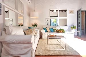 ein Wohnzimmer mit einer weißen Couch und einem Tisch in der Unterkunft Aljarafe Paradise by Valcambre in Castilleja de la Cuesta