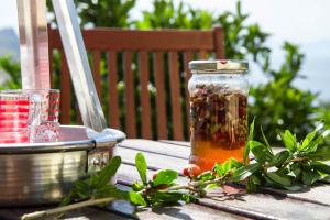 a jar of jam sitting on a table with herbs at Aelia & Melitta Villas in Perdika