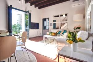 ein Wohnzimmer mit einer weißen Couch und einem Tisch in der Unterkunft Aljarafe Paradise by Valcambre in Castilleja de la Cuesta