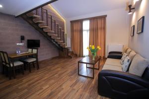 sala de estar con sofá y escalera en My Apartments Yerevan, en Ereván