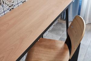 a wooden table with a wooden chair under it at Angelina Boutique Escape in Perdika