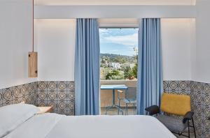 a bedroom with a bed and a window with a view at Angelina Boutique Escape in Perdika