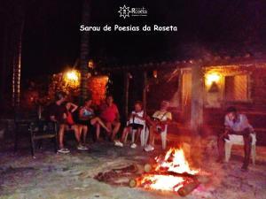 Un gruppo di persone sedute intorno al fuoco di Fazenda da Roseta - Turismo Rural e Passeios a Cavalo - a Baependi