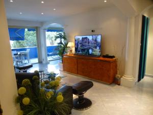 a living room with a flat screen tv on a entertainment center at GRAND LARGE Méditerranée in Cagnes-sur-Mer