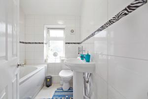 a white bathroom with a sink and a toilet at Dagenham Self catering House for Larger Groups with Free Parking in Dagenham
