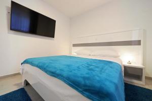 Schlafzimmer mit einem Bett und einem Flachbild-TV in der Unterkunft Apartmani Bida in Zadar
