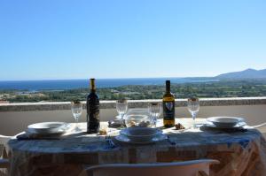 un tavolo con bottiglie di vino e bicchieri sul balcone di Appartamento Li Puntiti 3 a Budoni