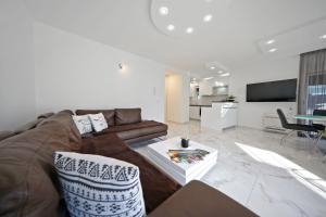 ein Wohnzimmer mit einem Sofa und einem Tisch in der Unterkunft Apartmani Bida in Zadar