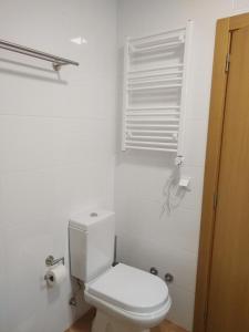 a white bathroom with a toilet and a window at Ribalta Beach Houses in Ericeira +16 photos