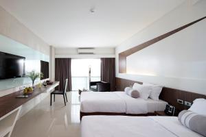a hotel room with two beds and a desk at Nine Forty One Hotel in Bangkok