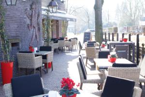 a patio with tables and chairs and a brick building at De Roode Leeuw Terborg in Terborg