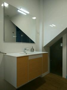 a bathroom with a sink and a large mirror at Ribalta Beach Houses in Ericeira