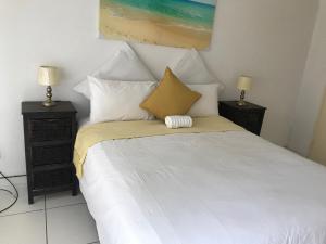 a bedroom with a bed with white sheets and pillows at Lala’s guest house in Johannesburg