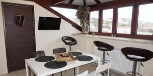 a dining room with a white table and black chairs at Fegaropetra studios in Syvota