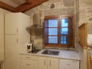 een keuken met een wastafel en een raam bij Casa Mariñeira in Combarro