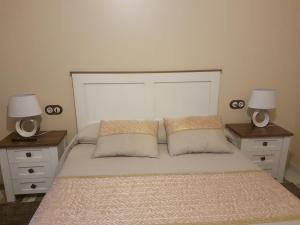 een slaapkamer met een groot bed met 2 nachtkastjes bij Casa Mariñeira in Combarro