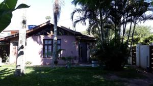 a house with palm trees in front of it at Floripa Beach House Hostel in Florianópolis