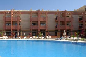 a swimming pool in front of a hotel at Leo Punta Umbría in Punta Umbría
