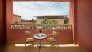a patio with a table and chairs on a balcony at Leo Punta Umbría in Punta Umbría