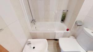 a white bathroom with a toilet and a bath tub at Leo Punta Umbría in Punta Umbría