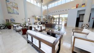 a lobby with white chairs and tables in a building at Leo Punta Umbría in Punta Umbría