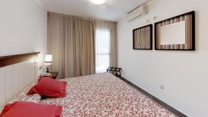 a bedroom with a large bed with red pillows on it at Leo Punta Umbría in Punta Umbría