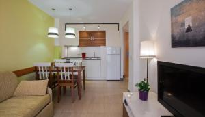 a living room and kitchen with a couch and a table at Leo Punta Umbría in Punta Umbría