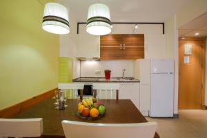 a kitchen with a table with a bowl of fruit on it at Leo Punta Umbría in Punta Umbría